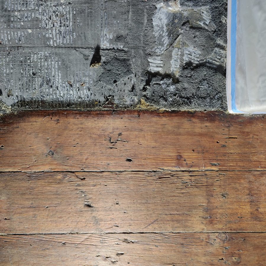 Old carpet adhesive covering the edge of the boards