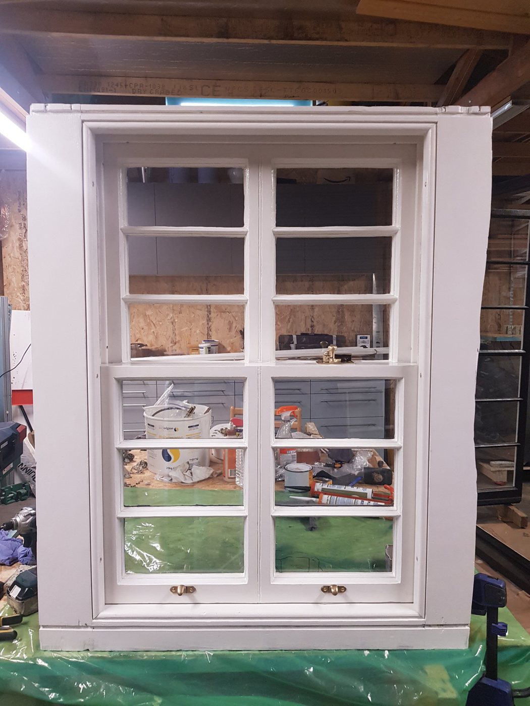 Restored sash window with brass fittings, in the workshop