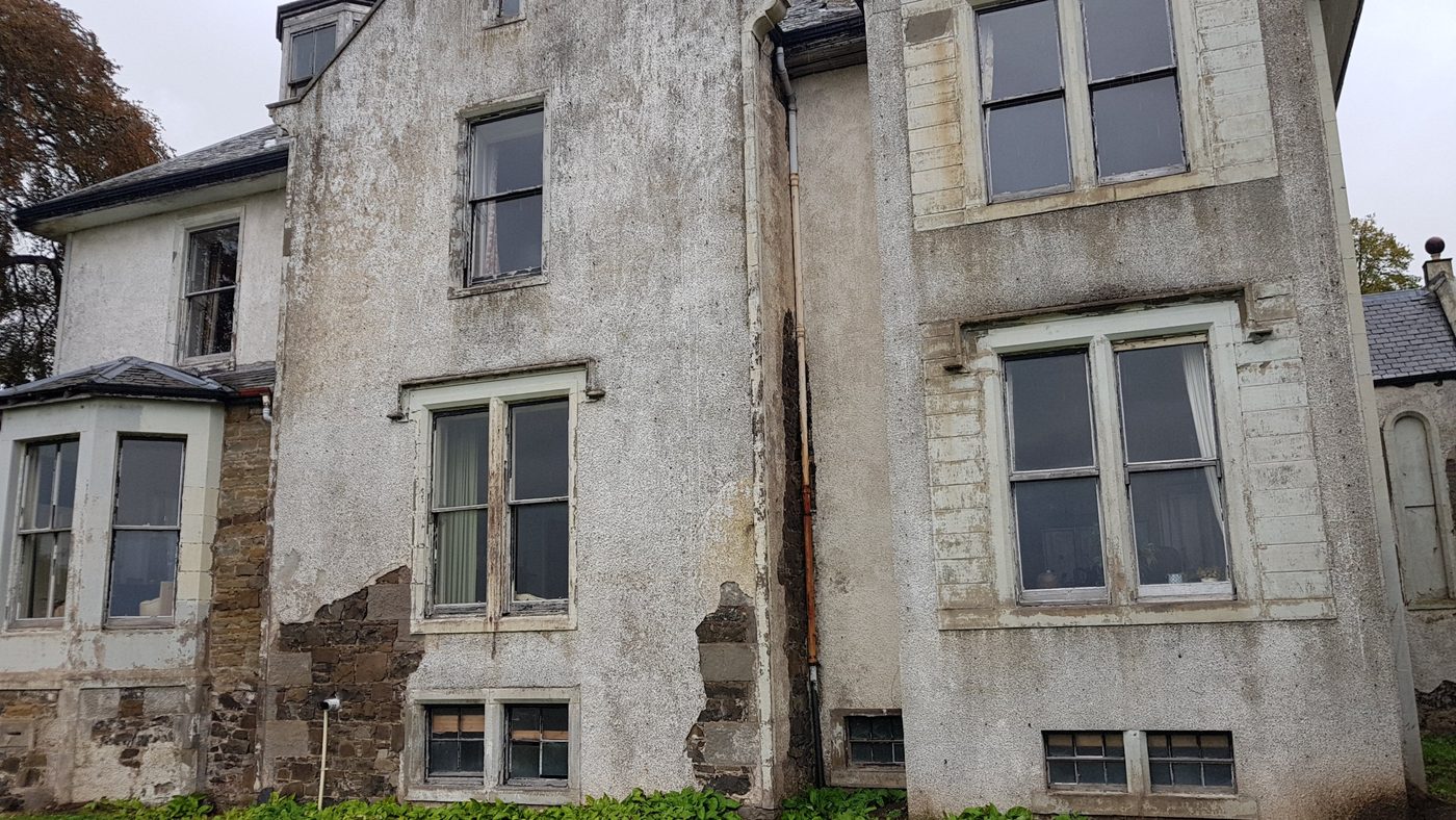 Garden front with failing harling and weathered sash windows