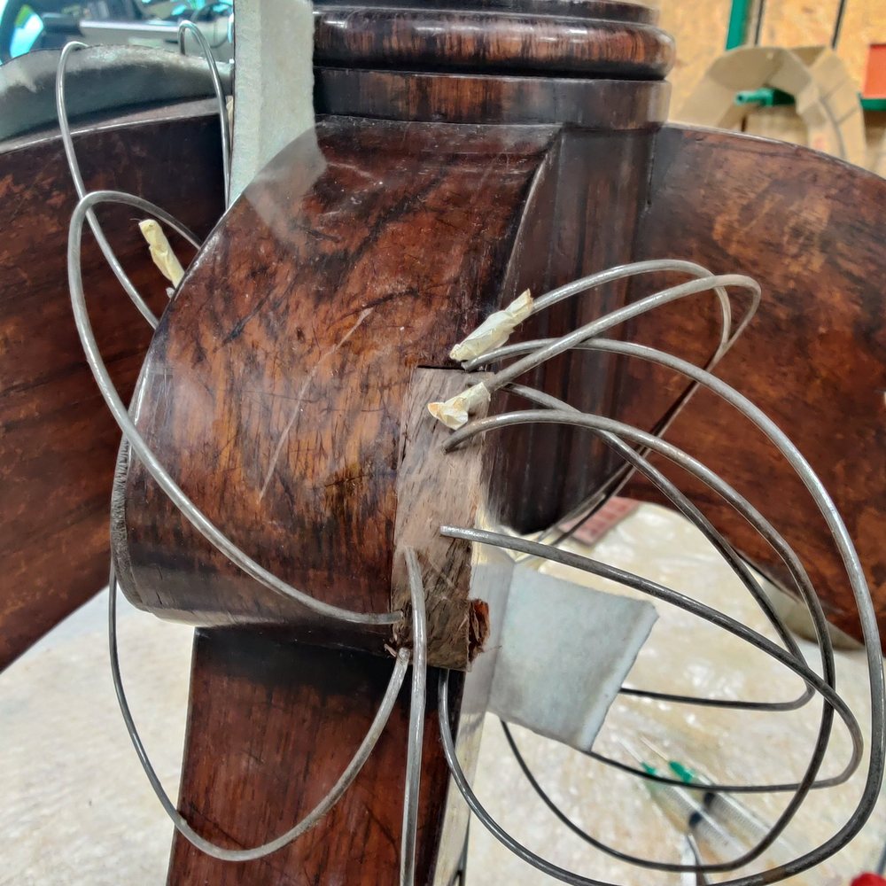 A split antique pedestal being re-glued and clamped in the workshop