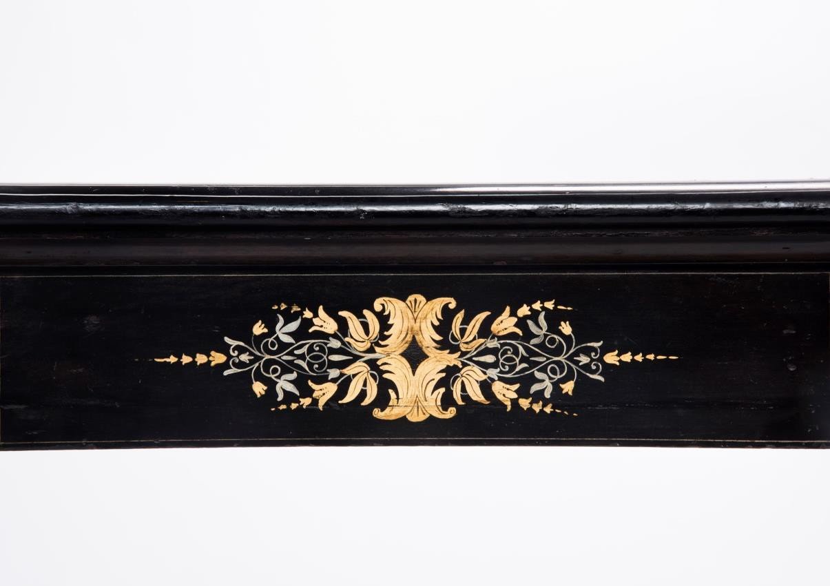 Gilded and painted decoration on the front rail of the stand