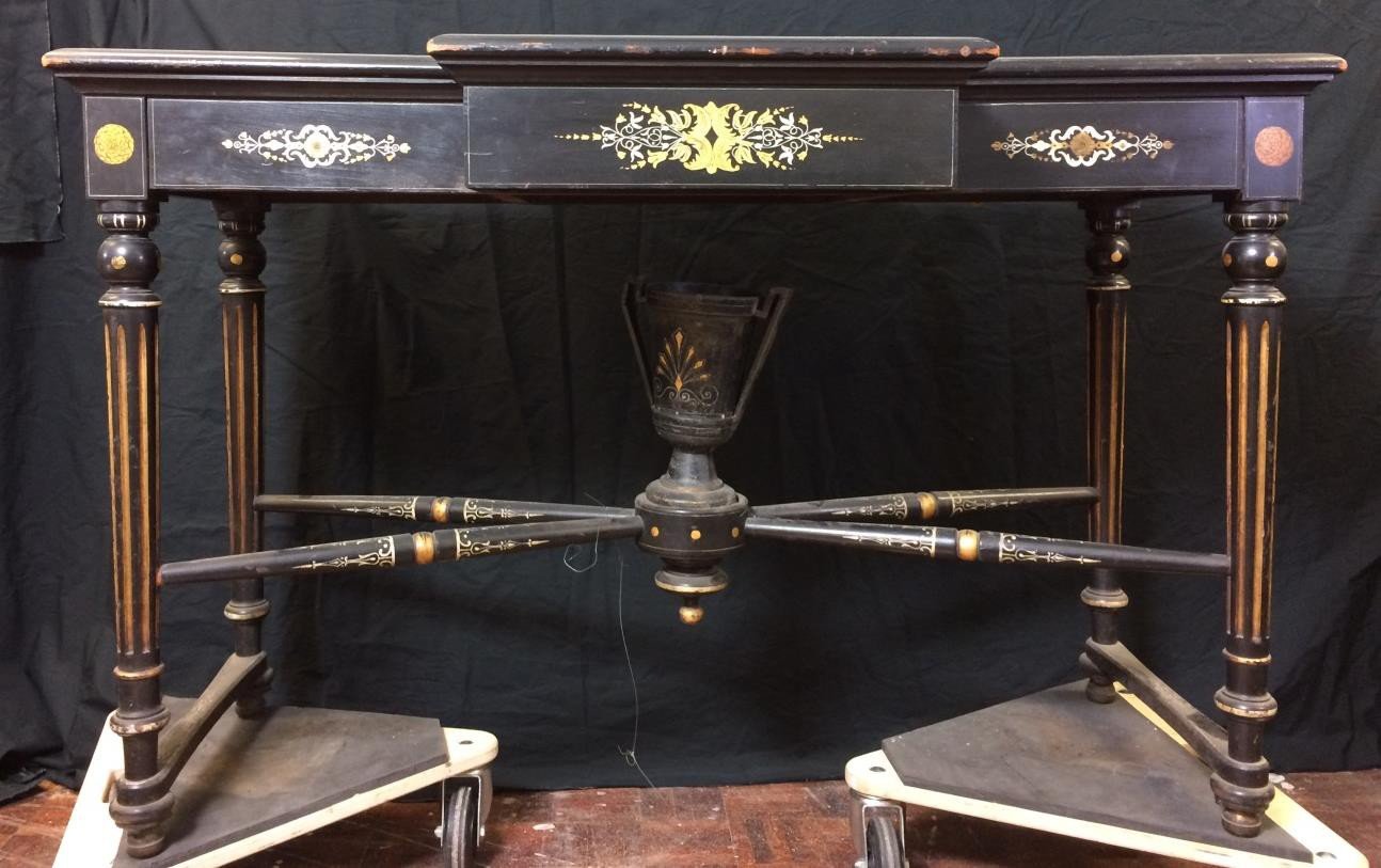 The ebonised stand before treatment, dulled by dirt, with worn finish and gilding