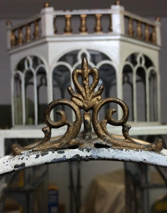 Gilded cresting with dirt and flaking paint below it